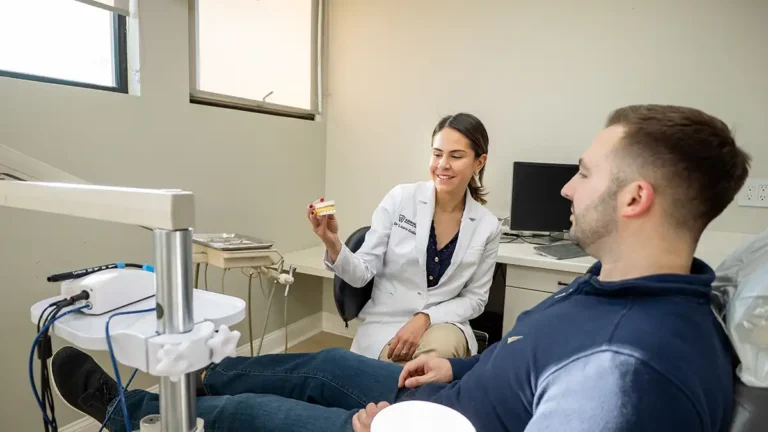 Dr. Laura Galiazzo showing a tooth model to a patient.